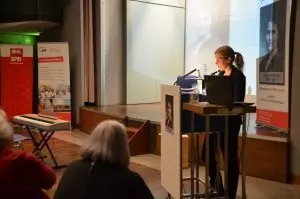 Katrin Schulz, Vorsitzende der Arbeitsgemeinschaft sozialdemokratischer Frauen in der SPD (AsF) steht rechts im Bild an einem Rednerpult und spricht zu den rund 200 Gästen im Ständehaussaal.