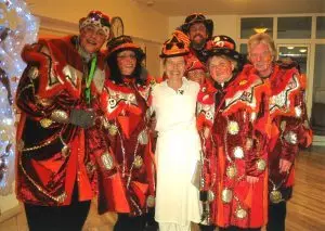 Auf dem Bild ist eine Gruppe von sechs Menschen zu sehen, die sich als Hexen verkleidet haben. Ihre Kostüme sind rot gemustert.