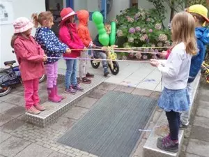 Kinder stehen sich gegenüber und spielen Gummi-Twist.