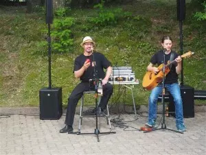 Ein Mann am Mirkophon und ein Mann mit Gitarrre