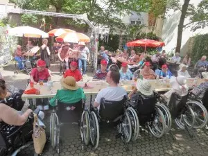 Ein Gruppe von Menschen sitzt an einem langen Tisch im Freien.
