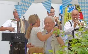 Ein Mann und eine Frau tanzen zu bayrischer Live-Musik.