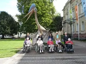 Eine Gruppe von Rollstuhlfahrern steht vor dem Naturkundemuseum.