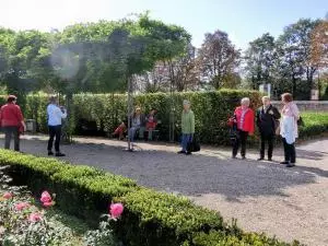 Menschen spazieren durch den Bruchsaler Schlosspark.