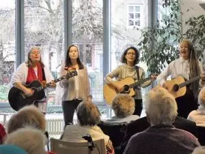 Vier Frauen Singen und spielen Gitarre