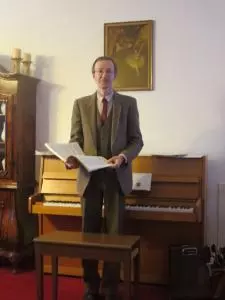 Ein Mann steht vor einem Klavier.