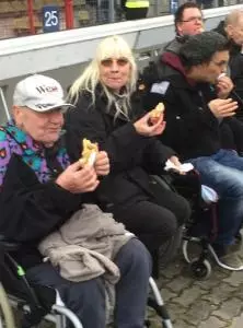 Menschen sitzen zusammen und essen Bratwurst.