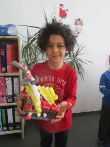 Ein KInd hält ein gebasteltes Piratenschiff fest.