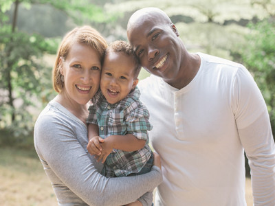 Weiße Frau und schwarzer Mann mit ihrem Kind.