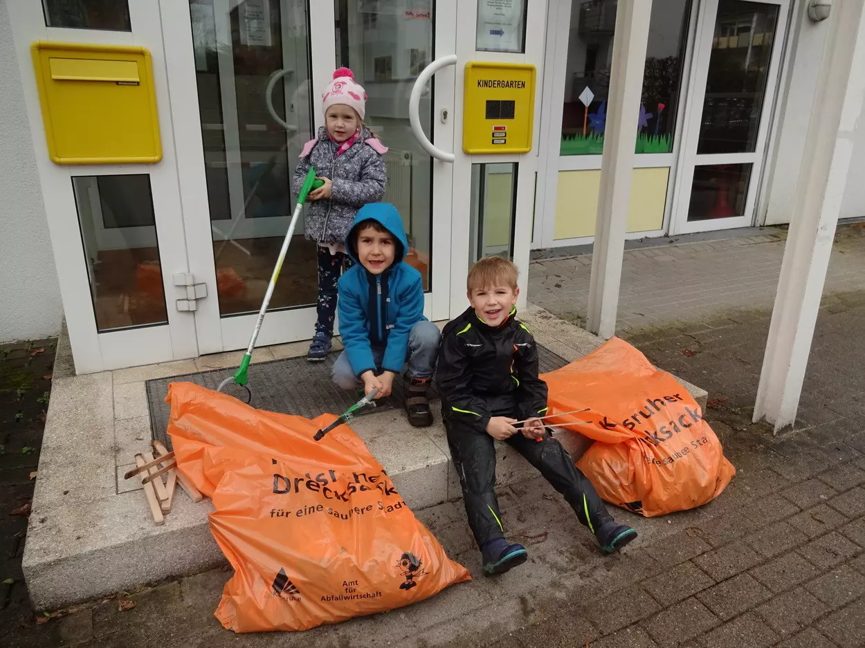 Kinder sammeln Müll auf der Straße.
