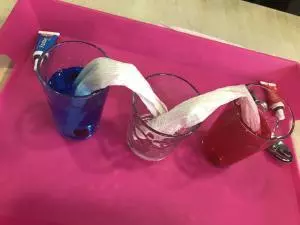 Gläser mit farbigem Wasser und Toilettenpapier.