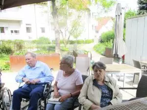 Senioren sitzen im Garten.