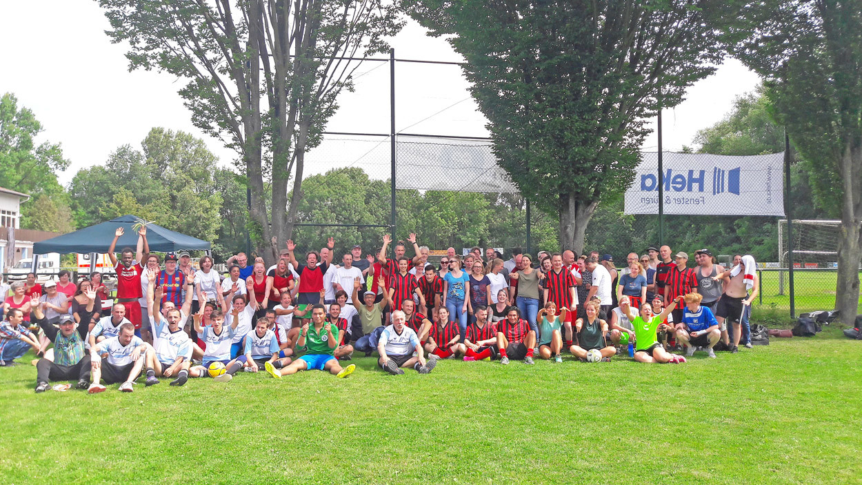 Gruppenfoto von Menschen auf einem Fußballplatz.