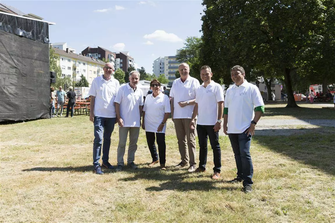 Sechs Menschen stehen auf einer Wiese.