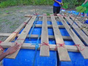Ein Floß wird aus Holzlatten gebaut.