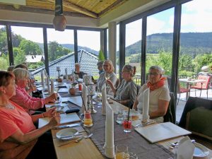 Ältere Menschen sitzen an einem Tisch.