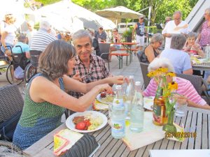 Ein Mann und eine Frau sitzen an einem Tisch und essen Grillwurst.