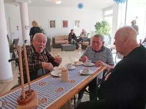 Männer sitzen zusammen an einem Tisch und trinken Bier.