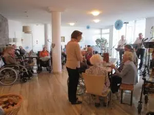 Blick in den Raum eines Seniorenzentrums mit Menschen während einer Feier.