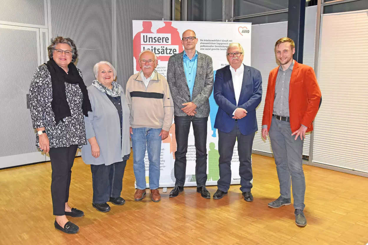 Eine Gruppe von Menschen steht zusammen vor einem Roll-up in einer Halle.