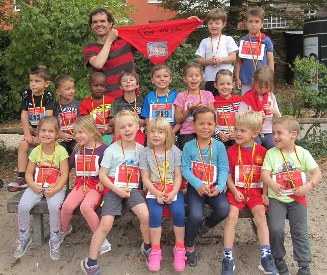 Eine Gruppe von Kindern sitzt mit Laufnummern zusammen.