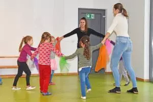 Kinder stehen im Kreis und fassen sich an den Händen.