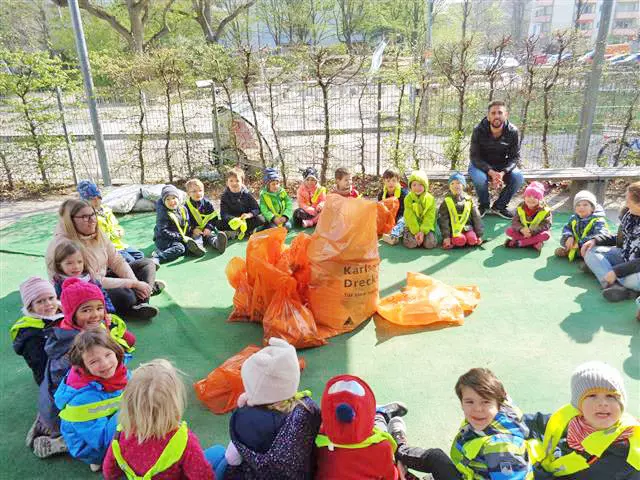 Kinder haben Müllsäcke in den Händen und sammeln Dreck ein.