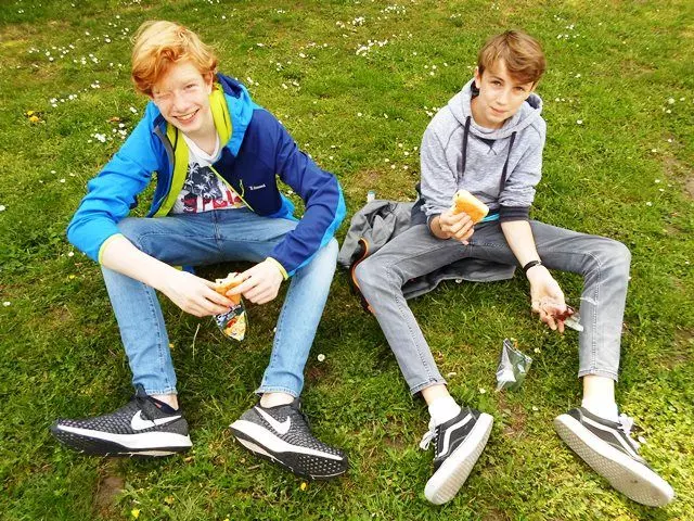 Zwei Jugendliche sitzen auf einer Wiese.