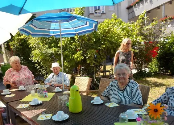 Seniorinnen sitzen gemeinsam an einem Tisch bei Kaffee und Kuchen