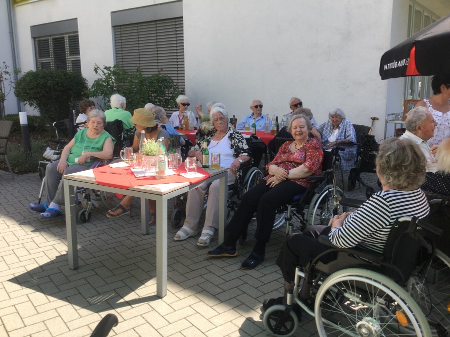Seniorinnen sitzen beim Sommerfest zusammen.