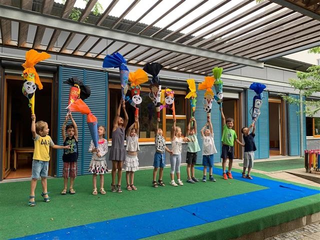 Vorschulkinder strecken ihr selbstgebastelten Schultüten in die Höhe