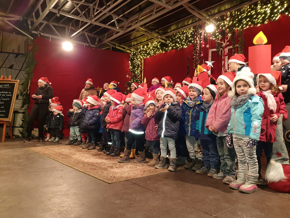 Kinder singen auf einem Weihnachtsmarkt