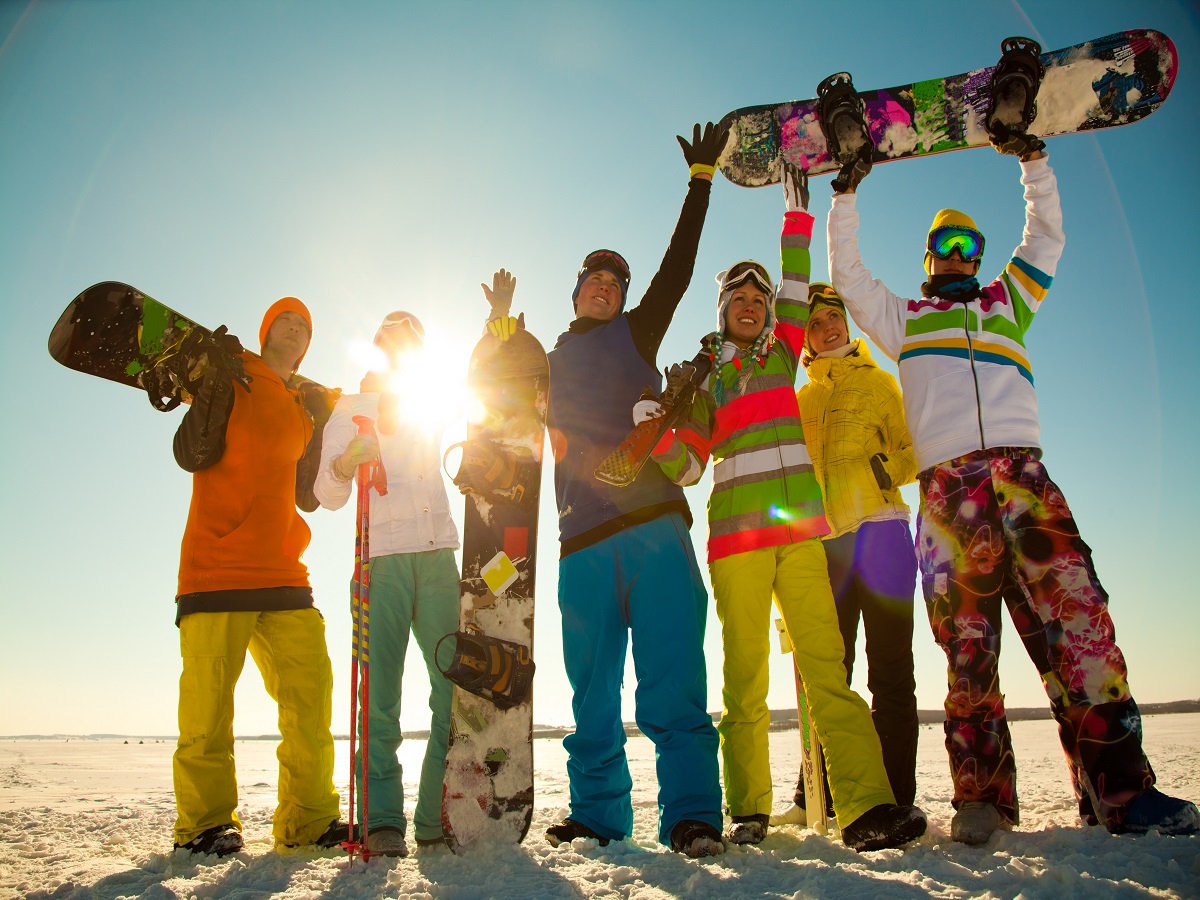 Group of young people with snowboard on ski holiday in mountains