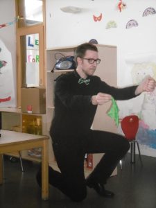 Ein Mann kniet auf dem Boden und führt einen Zaubertrick vor.