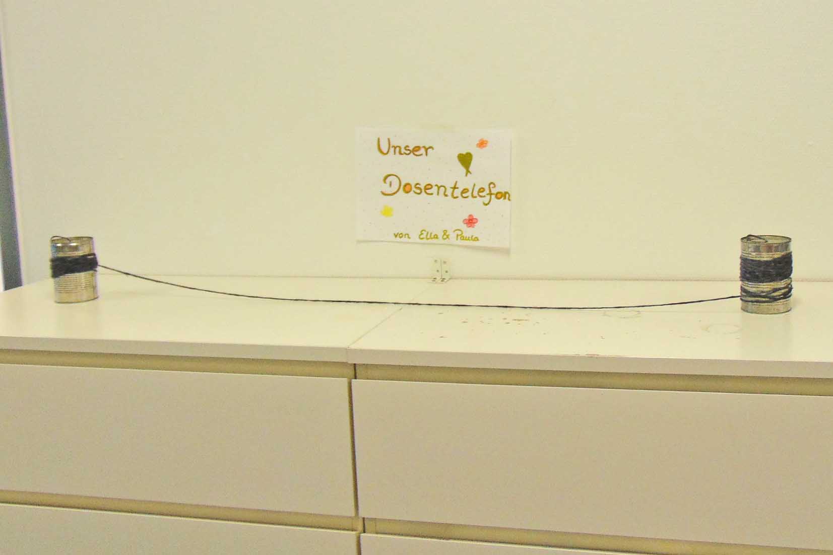 Zwei Dosen sind verbunden mit einer Schnur.