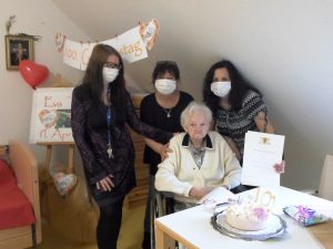 Drei Frauen gratulieren einer Seniorin zum 100. Geburtstag.