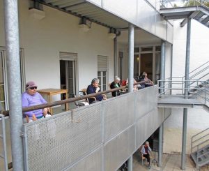 Senior*innen sitzen auf den Balkonen.