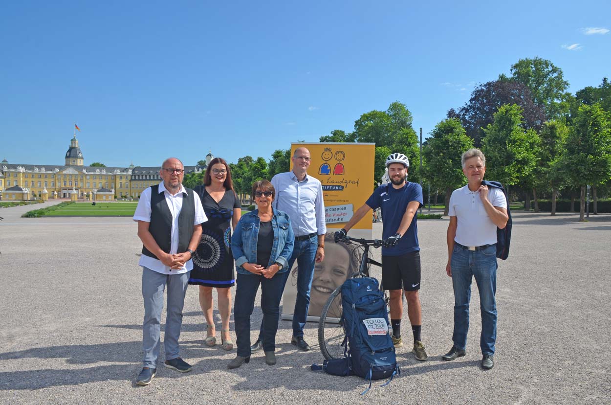 Eine Gruppe von Menschen steht vor dem Karlsruher Schloss.