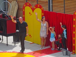 Eine Familie mit drei Kindern winkt.