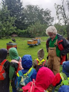 Kinder beim Imker vor den Bienenkästen