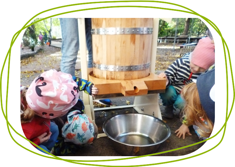 Kinder beim Apfelsaft pressen