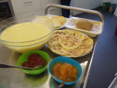 Ein Buffetwagen mit einer großen Schüssel Suppe, frischen Crêpes und verschiedenen Fruchtaufstrichen für das gemeinsame Essen.