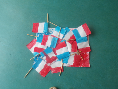 Viele bunt bemalte, gebastelte Trikolore-Flaggen aus Papier als Teil der Projekttage zur deutsch-französischen Freundschaft.