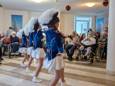 Junge Gardetänzerinnen in blau-weißen Uniformen zeigen eine schwungvolle Choreografie für die Bewohner des Hanne-Landgraf-Hauses.