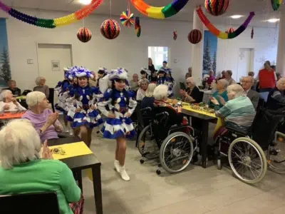 Blau-weiße Jugendgarde des Daxlandener Karnevalvereins tanzt für applaudierende Senioren im Seniorenzentrum Grünwinkel.