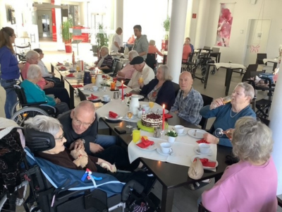 Bewohnerinnen im Seniorenzentrum Grünwinkel sitzen gemeinsam an gedeckten Tischen und feiern Geburtstagskaffee mit Kuchen und Getränken.