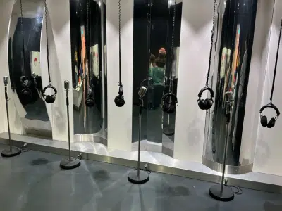 Vorschulkinder testen im Toccarion Baden-Baden eine Stimmstation mit Mikrofonen und Kopfhörern, um ihre Stimmen zu verändern und Klänge zu erforschen.