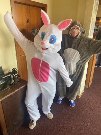 Menschen in Hasen-Kostümen halten die Arme hoch in die Luft und machen fröhliche Gesichter.