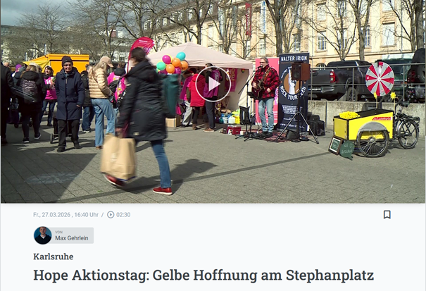 Menschen am Infostand und Musiker beim HOPE-Aktionstag auf dem Stephanplatz in Karlsruhe.