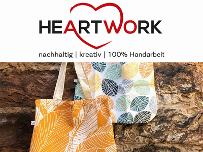Titelseite des HEARTWORK-Produktkatalogs mit handgefertigten Stofftaschen vor einer Steinwand.